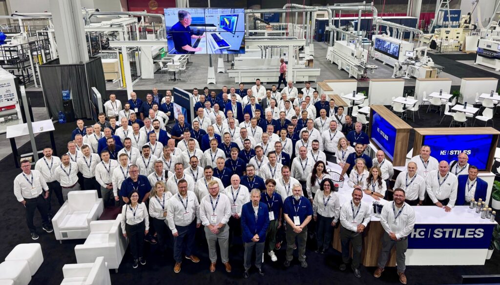 Stiles Machinery team members pose among displays and machines during the IWF 2024 conference.
