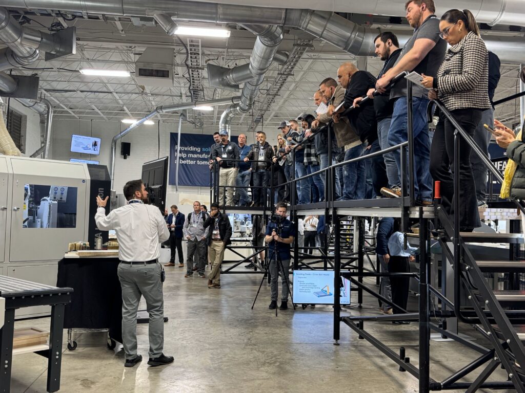 A Stiles Machinery representative demonstrates the latest in sanding capabilities to an audience in their showroom.
